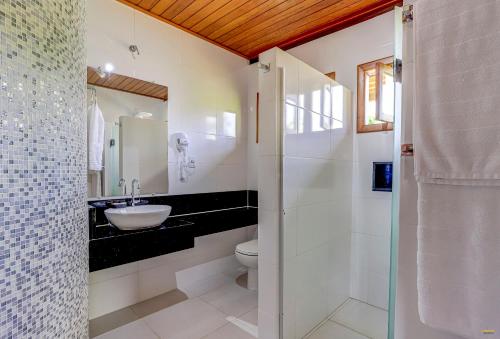 uma casa de banho branca com um lavatório e um WC em Pousada Atlântica em Itacaré