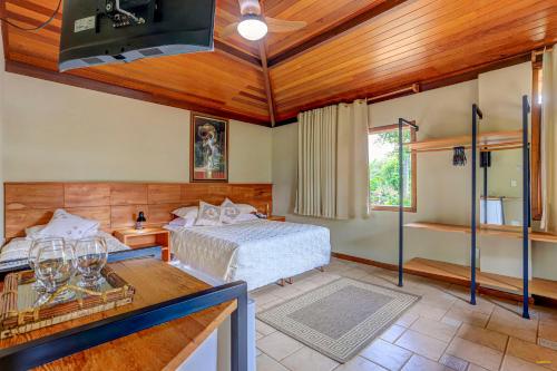 um quarto com uma cama e uma mesa num quarto em Pousada Atlântica em Itacaré