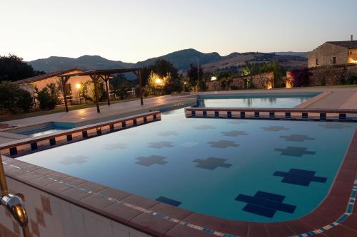 a pool in a resort with mountains in the background at Le Querce di Cota in Troina