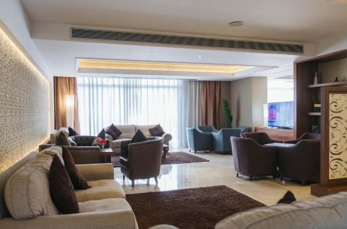 a hotel lobby with couches and chairs and a television at AZ Hôtels Zeralda in Zeralda