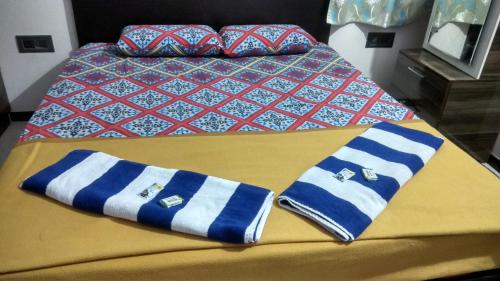 a bed with blue and white striped towels on it at Rocky Homestay in Hampi