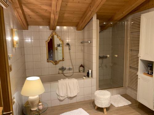 a bathroom with a shower and a mirror and a lamp at Gästehaus Wimmer in Mittersill