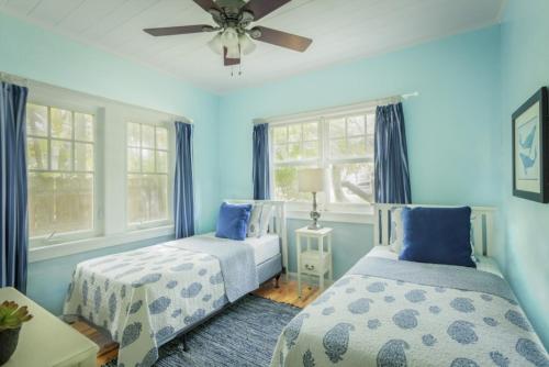 um quarto azul com 2 camas e uma ventoinha de tecto em Paradise Cottage Private Pool! Home em West Palm Beach