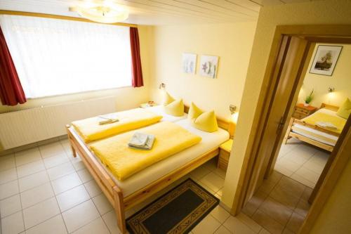 a bedroom with a bed with yellow sheets and a window at Ferienhof Schön in Zempin
