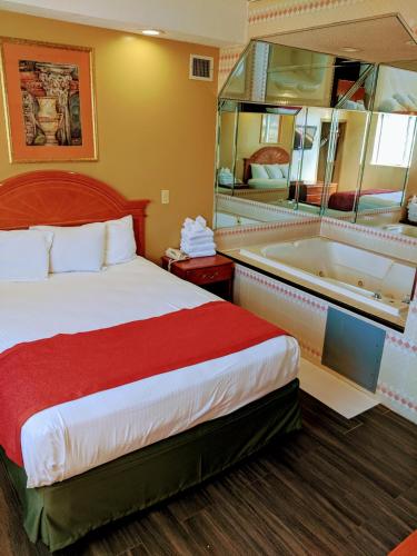 a hotel room with a bed and a bath tub at Jets Motor Inn in Queens