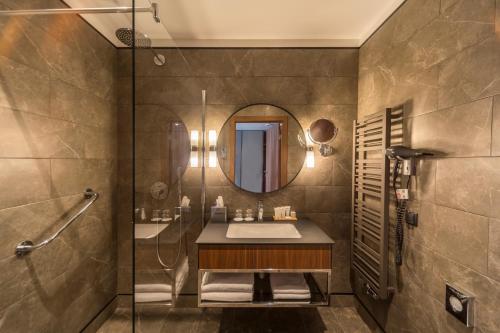 a bathroom with a sink and a shower and a mirror at Radisson Hotel & Apartments Gdansk in Gdańsk