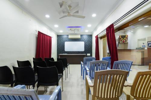 a conference room with blue chairs and a screen at Hotel Lakshmi Residency in Visakhapatnam