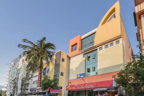 a building with a palm tree in front of it at Hotel Lakshmi Residency in Visakhapatnam