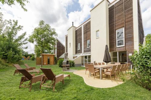 a patio with chairs and a table in a yard at Center Parcs Sauerland Winterberg-Medebach in Medebach