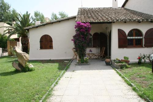 a white house with flowers on the side of it at Casa Stella Di Madel in Flumini di Quartu