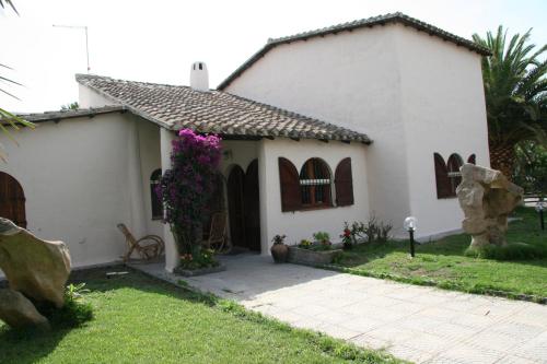 a small white house with flowers in the yard at Casa Stella Di Madel in Flumini di Quartu