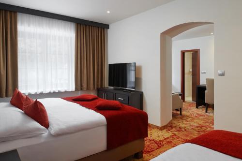 a hotel room with a bed and a flat screen tv at Hotel Singer in Ludvíkov