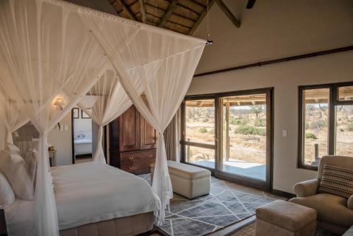 a bedroom with a bed with mosquito netting at Last Word Kitara in Klaserie Private Nature Reserve
