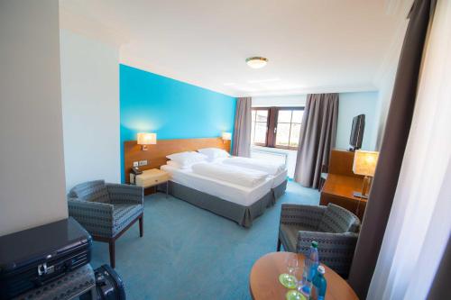 ローテンブルク・オプ・デア・タウバーにあるプリンツホテル ローテンブルクのベッド1台と椅子2脚が備わるホテルルームです。