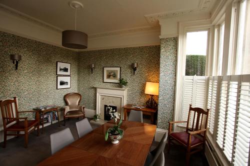 een woonkamer met een tafel en stoelen en een open haard bij Ascot House in Harrogate