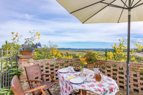 a table with an umbrella and chairs on a patio at Agriturismo Etrusco in Murlo