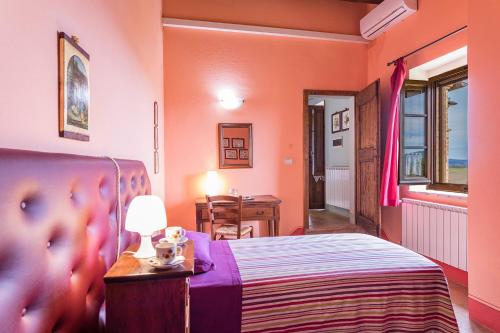 a bedroom with a bed and a table with a lamp at Agriturismo Etrusco in Murlo