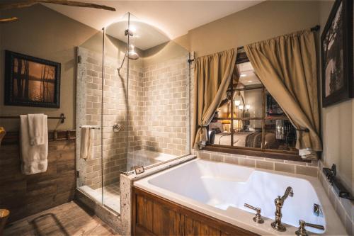 een badkamer met een groot bad en een douche bij Big Cypress Lodge in Memphis