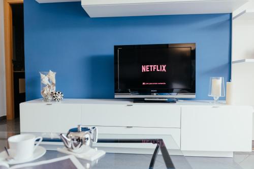 a tv sitting on top of a white table at Hauzify I Apartament Marina in Torredembarra