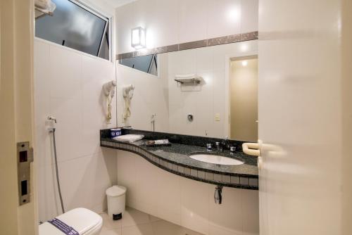 a bathroom with a sink and a mirror at A2 suites - Hotel e Motel in Brasilia