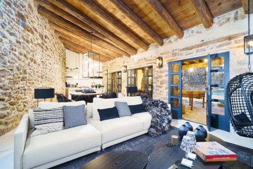 ein Wohnzimmer mit einem weißen Sofa und einer Ziegelwand in der Unterkunft Valencia Luxury - Mora de Rubielos con Piscina in Mora de Rubielos
