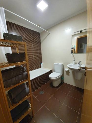 a bathroom with a toilet and a tub and a sink at Piso Rosalía de Castro in Allariz