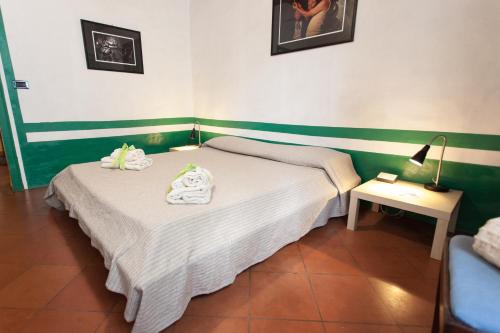 a bedroom with a bed with towels on it at Foresteria del Teatro Povero in Monticchiello