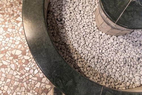 a walkway with a bunch of rocks on the ground at Belvedere Dolomites Flower Hotel in Moena