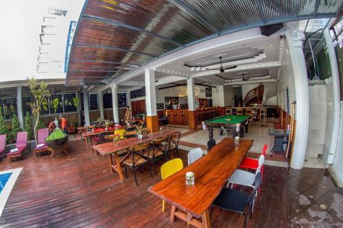 an empty restaurant with tables and ping pong tables at Poolside Villa in Phnom Penh