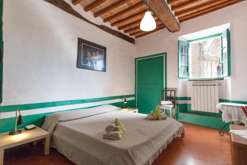 モンティッキエッロにあるForesteria del Teatro Poveroのベッドルーム1室(ベッド2台付)、緑のドアが備わります。
