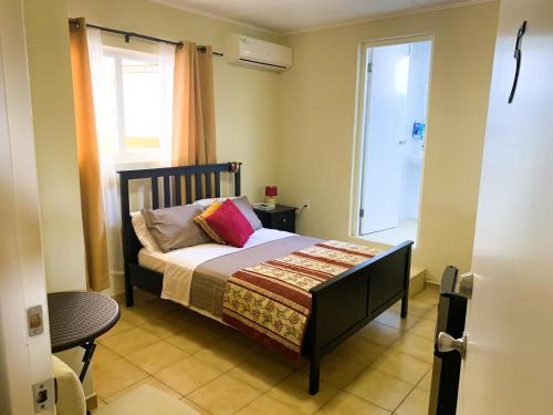 ein kleines Schlafzimmer mit einem Bett und einem Fenster in der Unterkunft Eve's Residence in Willemstad