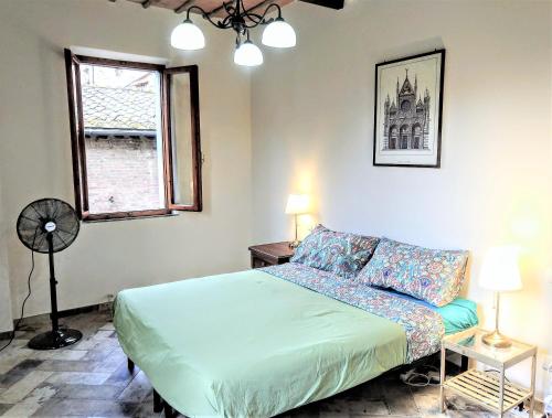1 dormitorio con 1 cama, ventana y ventilador en The AERIE - IL NIDO DELL AQUILA - central 8bd recentely renovated en Siena