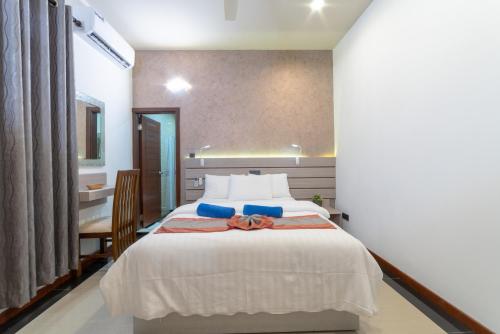a bedroom with a white bed with a bow on it at Nala Veli Villa in Ukulhas
