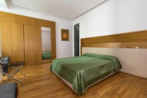 - une chambre avec un grand lit vert dans l'établissement Nerello Suites and Rooms, à Catane