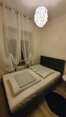 a bed in a room with a chandelier at Willa Nad Potokiem in Kudowa-Zdrój