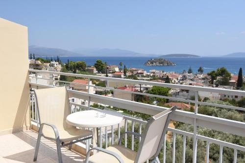 a balcony with a table and chairs and the ocean at Viaros Hotel Apartments in Tolo