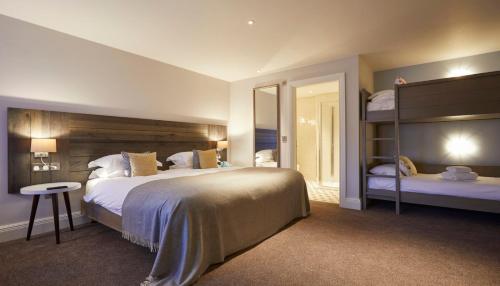 a bedroom with a large bed and two bunk beds at The Swan, Streatley, Berkshire in Streatley