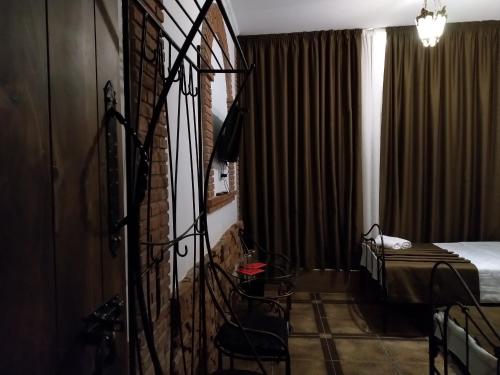 a room with a bed and a window with curtains at Janashia Hotels in Tbilisi City