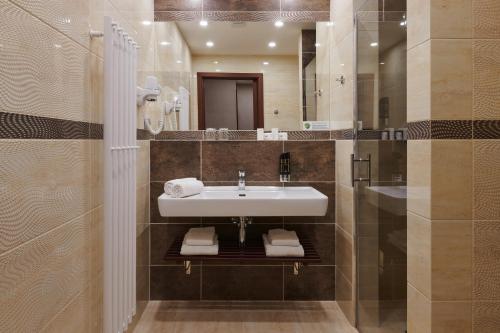 a bathroom with a sink and a mirror at Hotel Singer in Ludvíkov