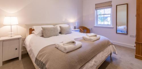 a bedroom with a large white bed with towels on it at Trinity Cottage, YORK in York