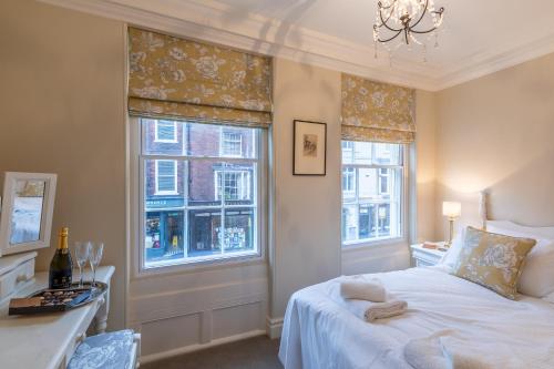 a bedroom with a bed and two windows at Apt 3, 71 Micklegate, YORK in York