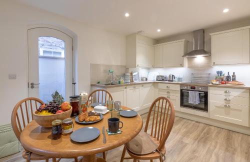 a kitchen with a table with a bowl of fruit on it at Trinity Cottage, YORK in York