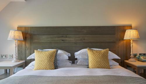 a bedroom with a large white bed with two lamps at The Swan, Streatley, Berkshire in Streatley