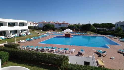 a large swimming pool with lounge chairs and a resort at Quinta Das Figueirinhas & Quintinha Village in Armação de Pêra