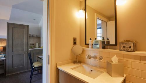 a bathroom with a sink and a mirror at The Swan, Streatley, Berkshire in Streatley