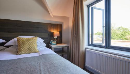 a bedroom with a large bed and a window at The Swan, Streatley, Berkshire in Streatley