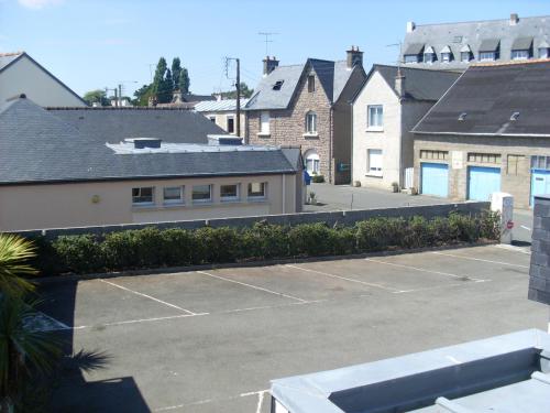 a parking lot with a tennis court and buildings at Hotel Restaurant de la Marne in Paimpol