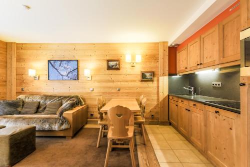 un salon avec un canapé et une table dans l'établissement Residence Les Chalets du Forum - maeva Home, à Courchevel