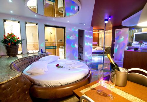 a bedroom with a bed and a table with a bottle of wine at A2 suites - Hotel e Motel in Brasilia