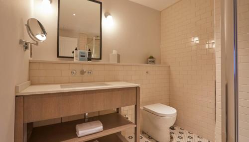 a bathroom with a sink and a toilet and a mirror at The Swan, Streatley, Berkshire in Streatley